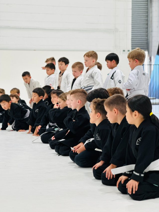Young Brazilian Jiu-Jitsu athletes lined up at an academy event